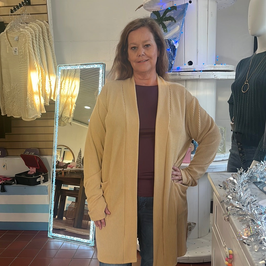 Reece Ribbed Cardigan available in sizes One Size and Plus Size. Brand: Blakely. 80% Polyester, 16% Rayon, 5% Spandex. Curry.