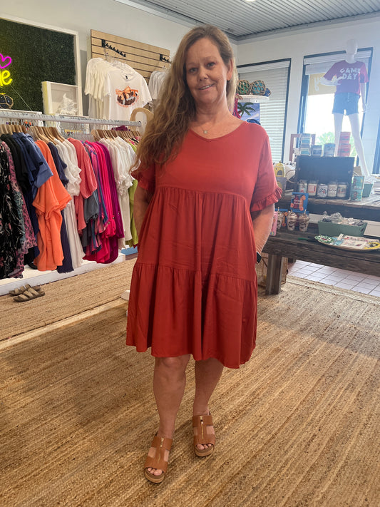 Rust V-Neck Tiered Dress available in sizes Small through Large.  97% Cotton,  3% Spandex.   1/2 Sleeve. Brand: Miss Sparkling