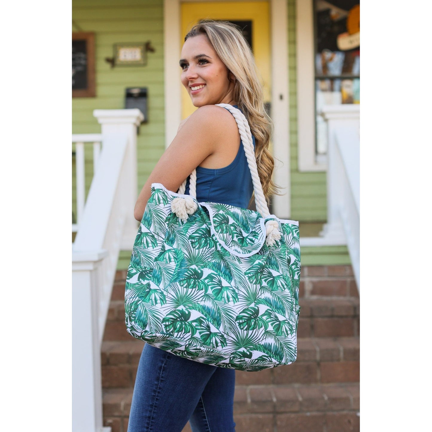 Rope handle beach bag with Palm Leaves.  Top flap closure. Polyester blend.  Bottom is approximately 23", top is approx. 17.5"